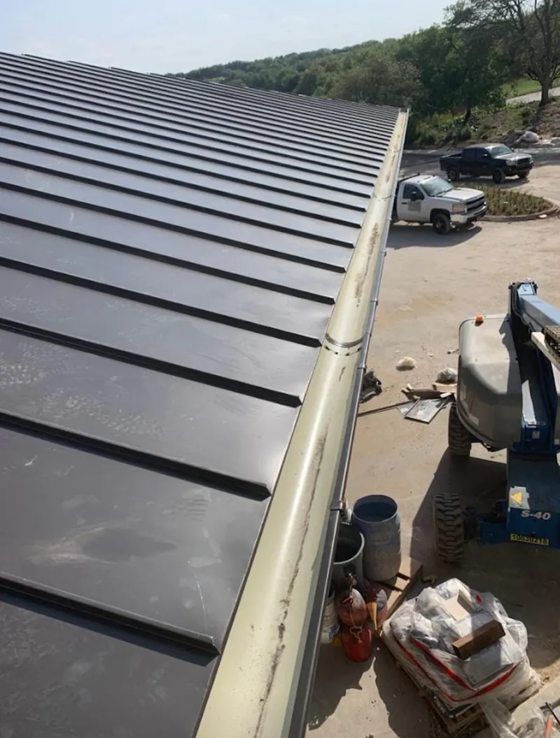 Standing seam panel and gutter detail on a metal roofing jobsite in Austell